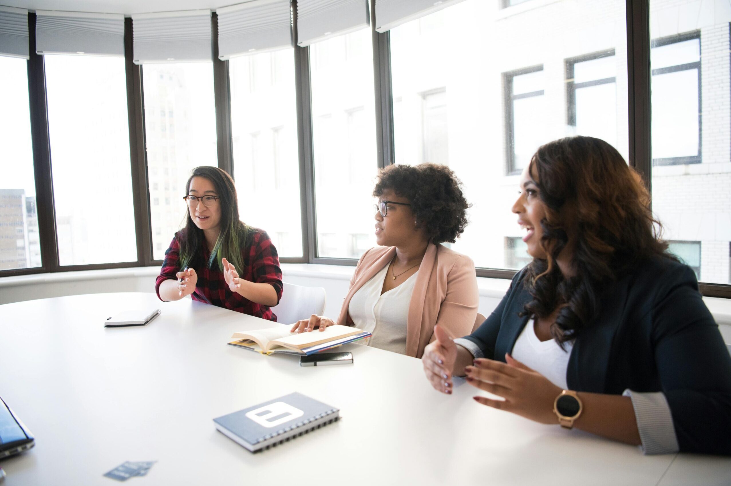 A diverse group of people sitting together in a room, engaged in a consulting session, symbolizing collaboration and professional growth.