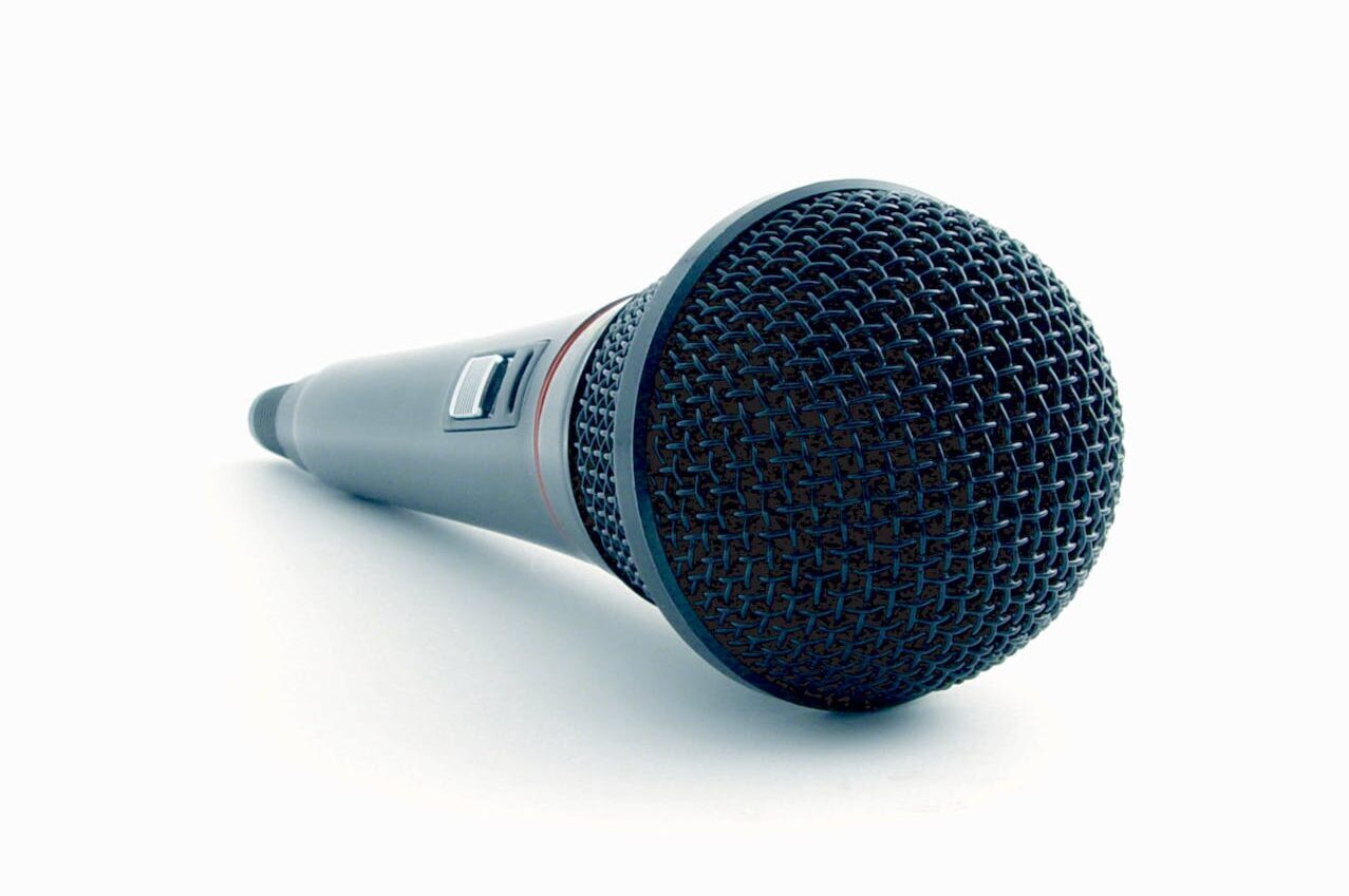 Close-up image of a microphone, symbolizing Maria MacAndrew's speaking engagements and invitation to hire her for public speaking.