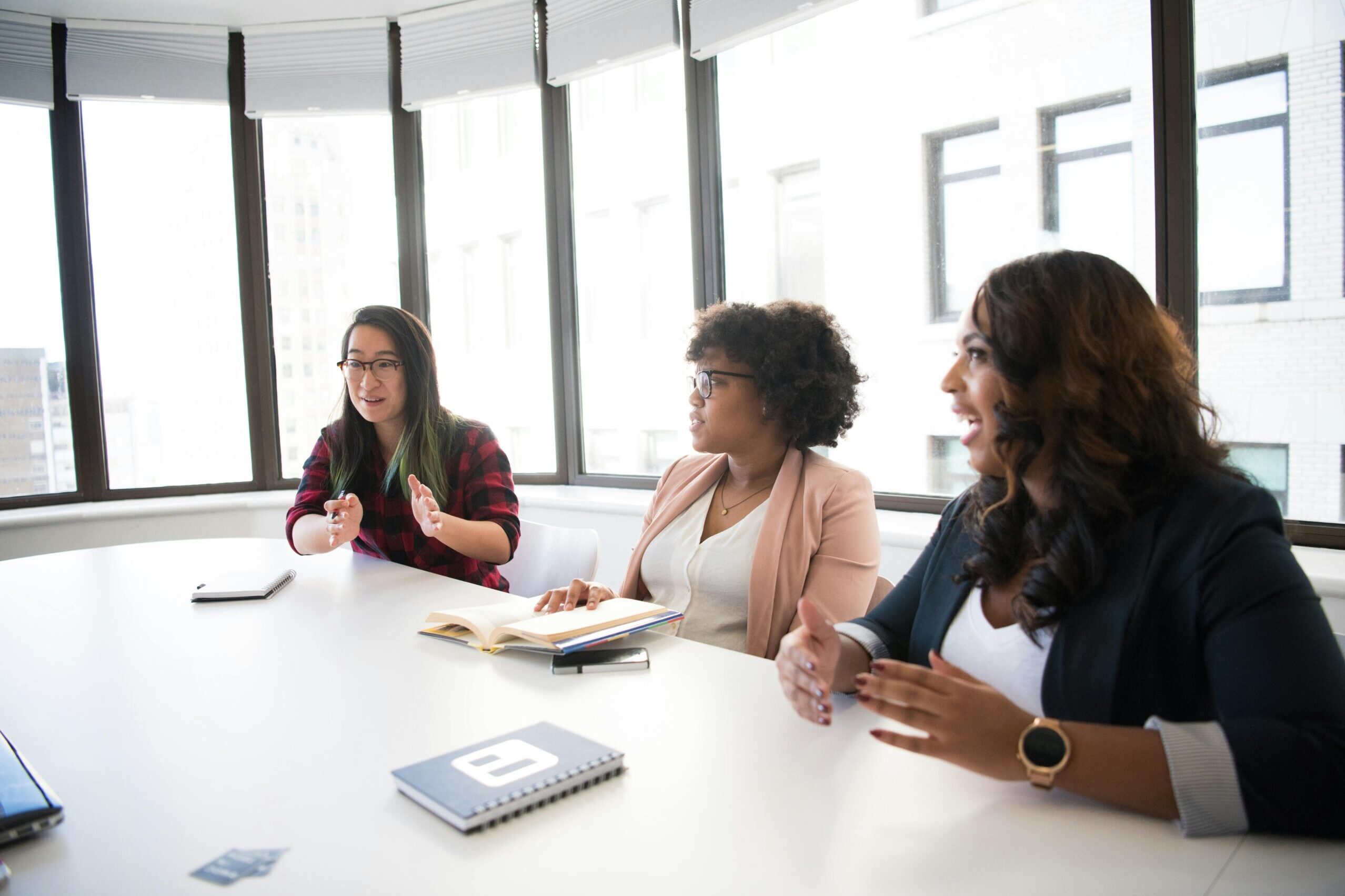 A diverse group of people sitting together in a room, engaged in a consulting session, symbolizing collaboration and professional growth.